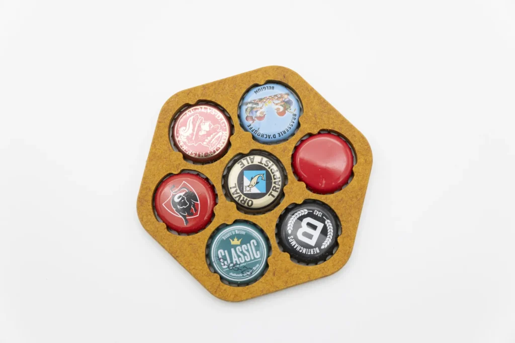 Porte-capsules hexagonal jaune garni de sept capsules de bière